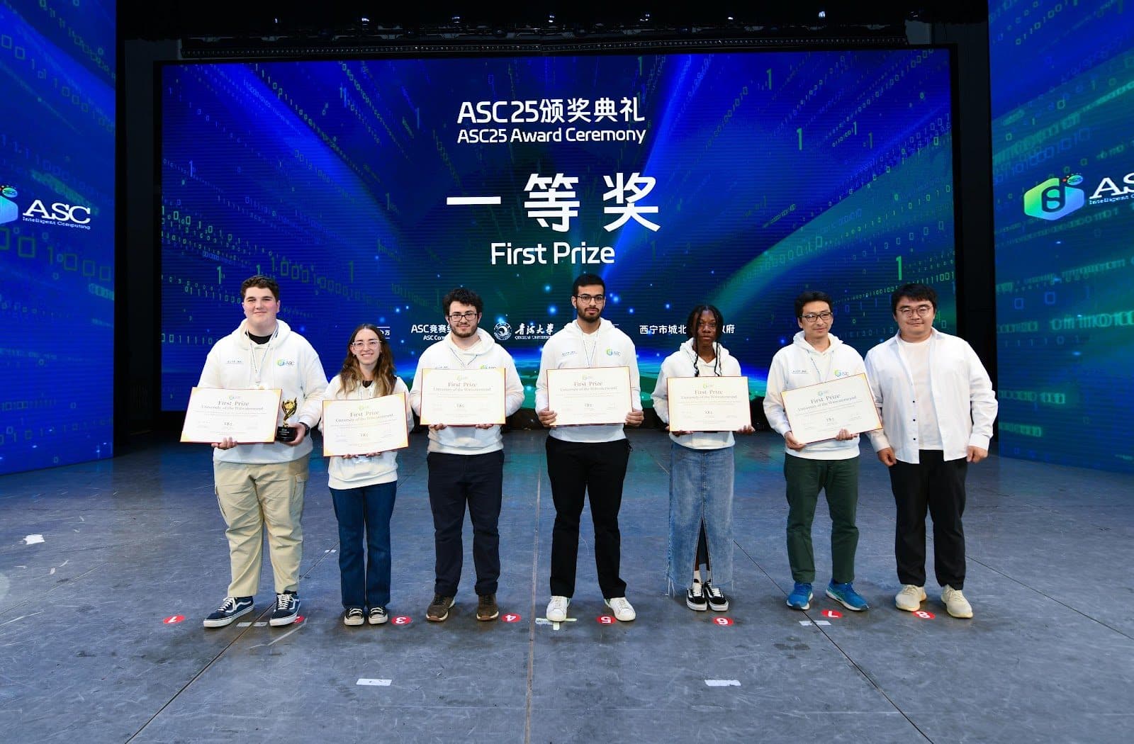 The Wits HPC team on stage at the ASC25 awards evening in Xining, China, each holding a certificate