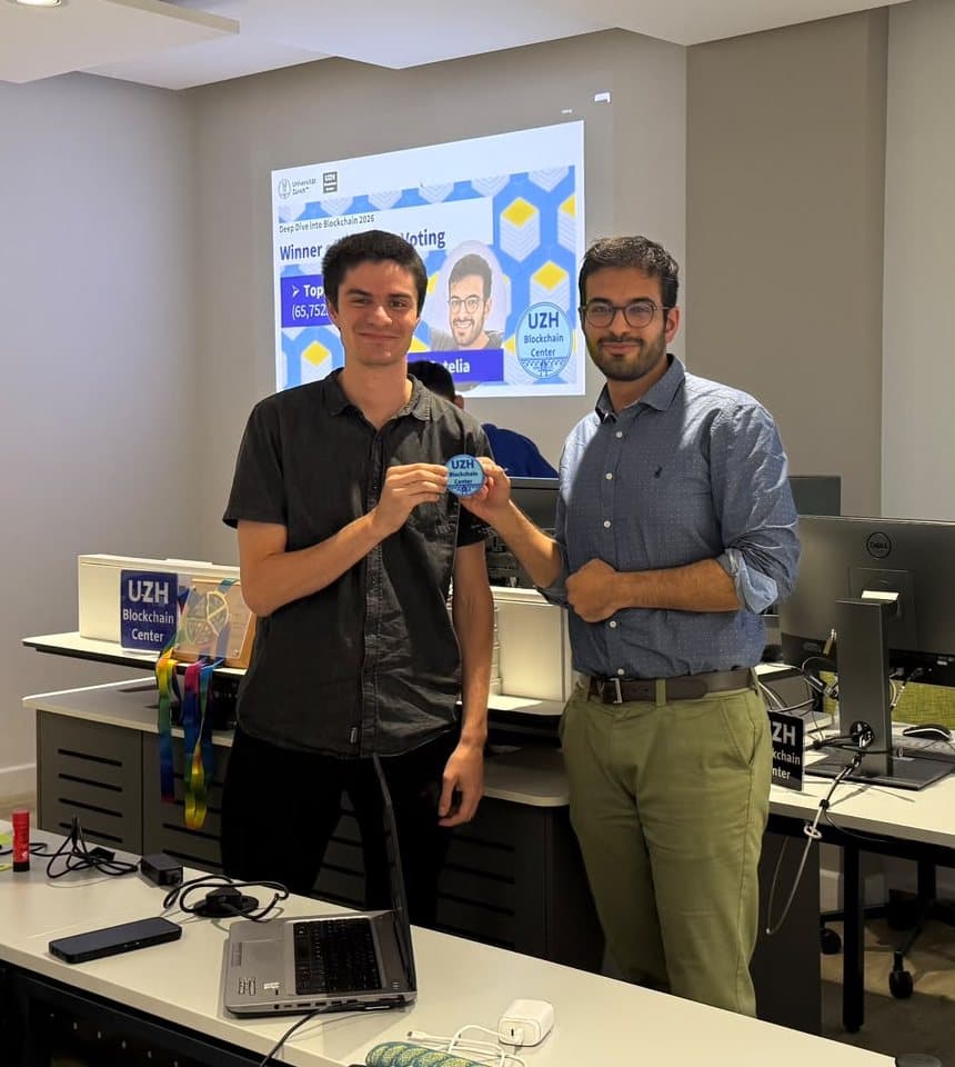 Talhah Patelia receiving a UZH Blockchain Center badge in front of a slide that names him as winner of the voting challenge